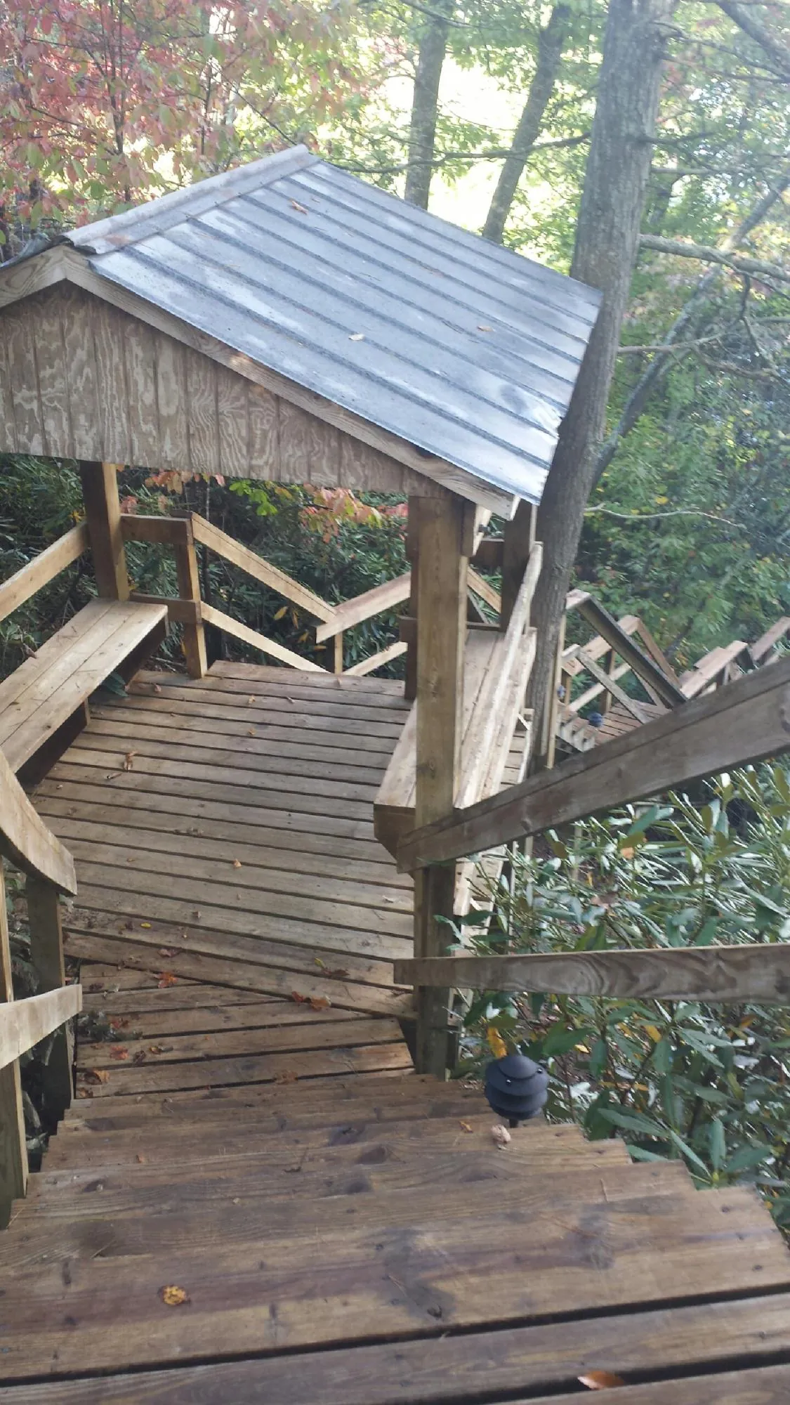 Metal roofed shelter over wooden steps on a wooded walkway — Skylight Repair & Installation work by our crew in Tivoli