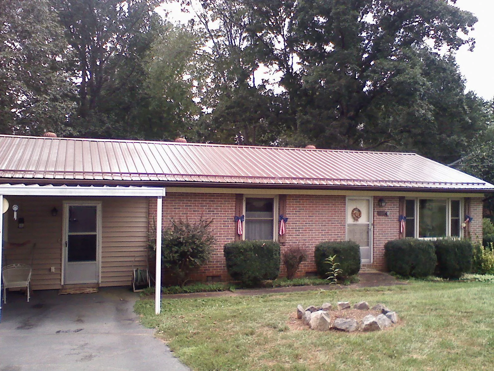 Bronze metal roof and carport on a brick ranch home — Roof Repair work by our crew in Tivoli